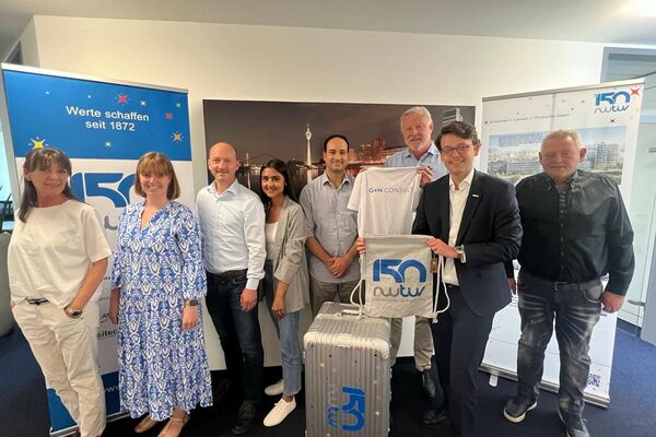 Mitarbeiter von Tochterunternehmen der RWTÜV Gruppe mit dem Jubiläumskoffer