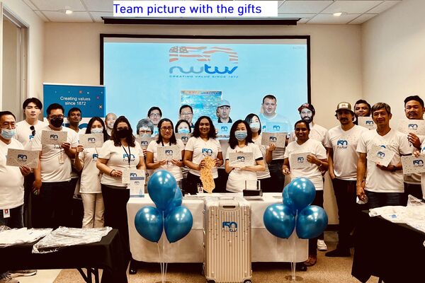 Mitarbeiter von Tochterunternehmen der RWTÜV Gruppe mit dem Jubiläumskoffer