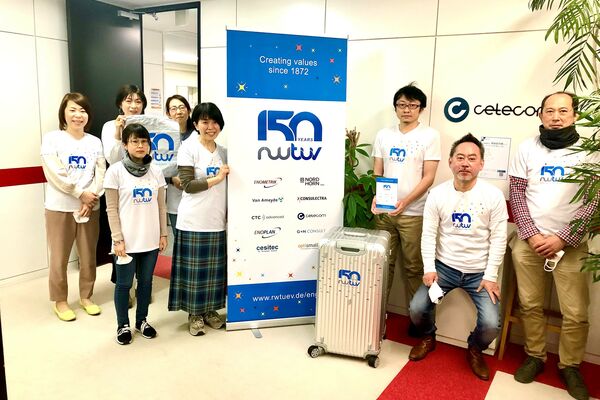 Mitarbeiter der CETECOM Japan mit dem Jubiläumskoffer